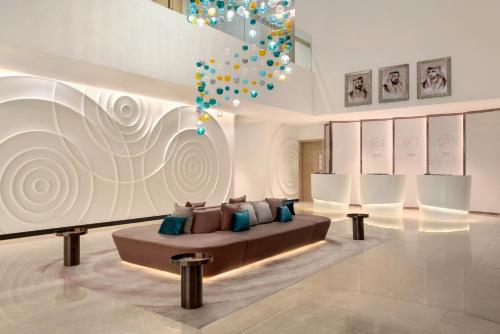 - un salon avec un canapé et un lustre dans l'établissement Wyndham Dubai Deira, à Dubaï