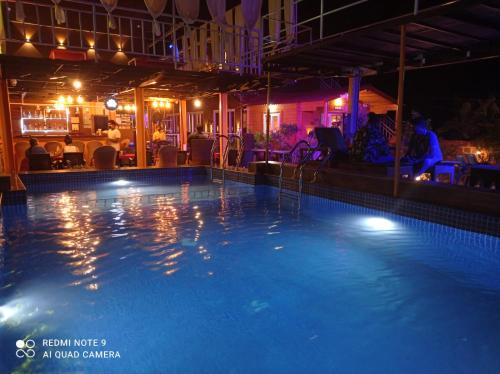 a swimming pool at night in a hotel at Vedana Retreat Arambol in Arambol