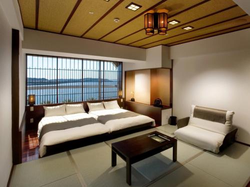 浜松市にある舘山寺サゴーロイヤルホテルのベッドルーム1室(ベッド1台、テーブル、椅子付)