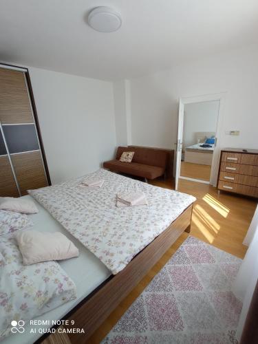 a bedroom with two beds and a living room at Apartman JulRich in Vrbov