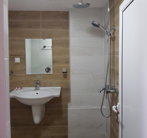 uma casa de banho com um lavatório e um chuveiro em Чилковата Къща em Banya