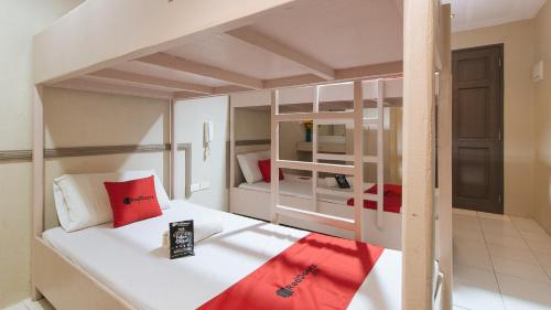 a bedroom with two bunk beds with red pillows at RedDoorz @ Bridgeway Hotel Tuguegarao City in Tuguegarao City