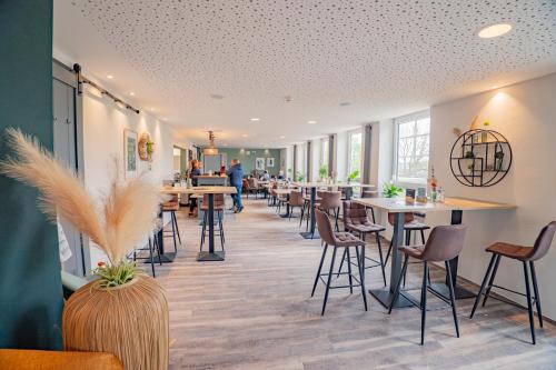 a restaurant with tables and chairs and people in the background at Haus Jagstblick in Kirchberg an der Jagst