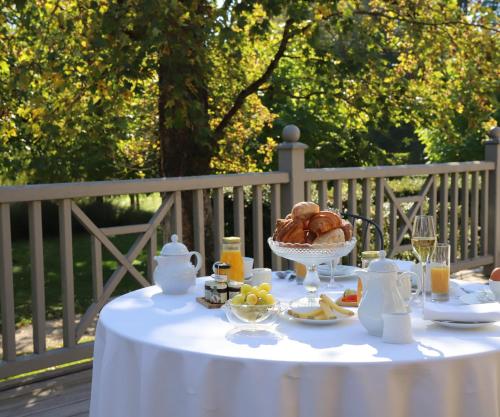 a table with a plate of food and a bowl of bread at Chateau De Germigney in Port-Lesney