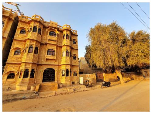 un grand bâtiment jaune assis sur le côté d'une rue dans l'établissement Hotel Ajanta Haveli, à Jaisalmer