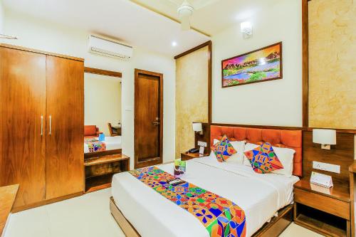 a bedroom with a bed and a desk and a bed at FabHotel Empire Suite in Mumbai