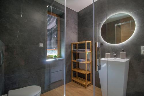 a bathroom with a toilet and a sink and a mirror at APARTAMENTY O&M Zawóz in Zawóz