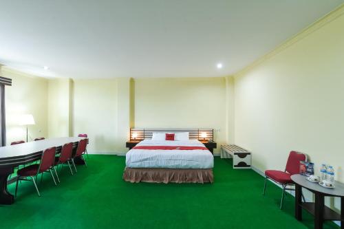 Habitación de hotel con cama, mesa y sillas en RedDoorz at Brother Homestay Kupang en Kupang