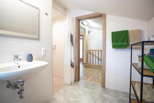 ein Bad mit einem Waschbecken und einem Spiegel in der Unterkunft Ferienwohnung Hoamat in Reutte