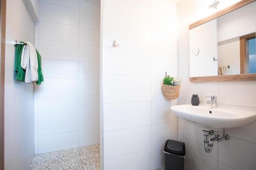 a white bathroom with a sink and a mirror at Ferienwohnung Hoamat in Reutte