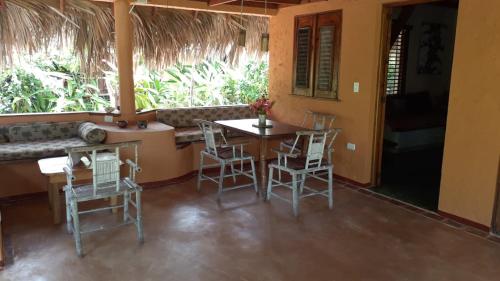 un comedor con mesa y sillas en una casa en Casa 3 amigos-Palm roofed house, en Las Galeras