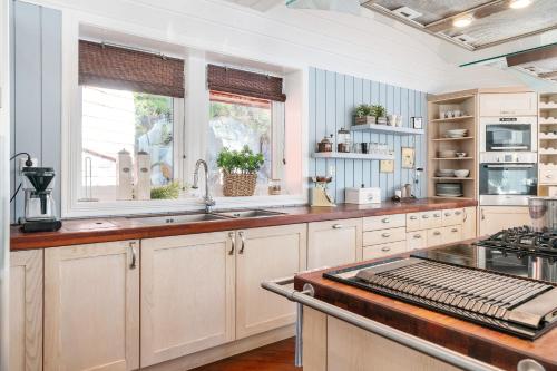 een keuken met witte kasten en een kookplaat oven bij Villa Oleanna in Lysekloster