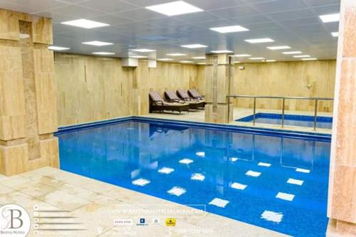 a large swimming pool with blue water in a building at Bristol Hotel Salalah in Salalah