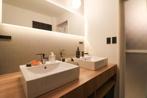 札幌市にあるTAKETO STAY Sumikawa Houseのバスルーム(白い洗面台、鏡付)