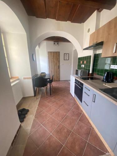 a kitchen with a counter and a table in it at Vila Lucia - Apartmán 1 in Plzeň