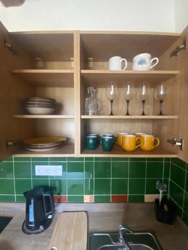 a kitchen with a sink and some plates and glasses at Vila Lucia - Apartmán 1 in Plzeň