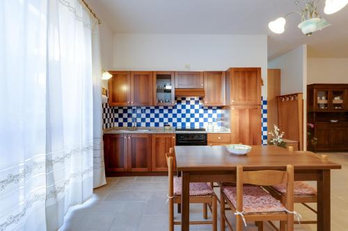a kitchen with a wooden table and chairs at Casa Vacanze Maria in Bosa