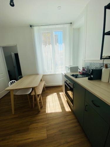 une cuisine avec une table en bois, une table et une table dans l'établissement RDC Cozy Central Flat/Free Parking, à Boulogne-sur-Mer