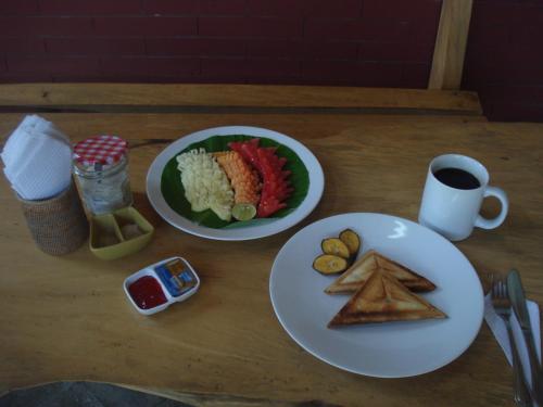 Una mesa con dos platos de comida y una taza de café. en Bulih Beach Bungalows, en Amed