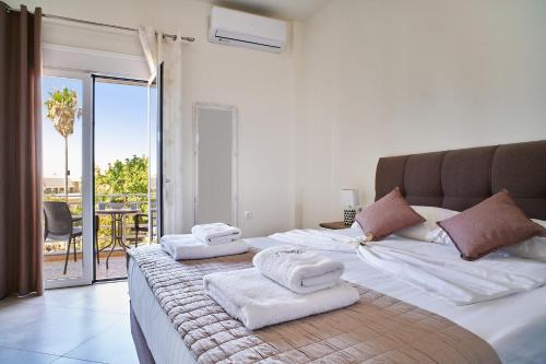 a bedroom with a large bed with towels on it at Bella Apartment in Kissamos