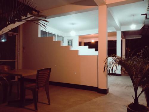 a dining room with a table and a staircase at Ella Jayamali Holiday Pavilion in Ella