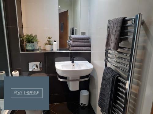 a bathroom with a sink and a mirror and towels at City Centre 2 Bedroomed Apartment - Great views - wifi in Sheffield