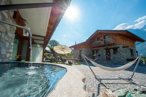 a patio with a hammock in front of a building at B&B Pousada Rio Aosta-servizi di Bed and breakfast in Aosta