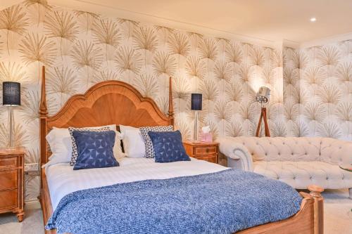 a bedroom with a bed and a couch at Lisburne Place - Luxury Three Bedroom Town House in Torquay