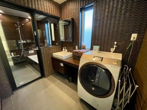 uma casa de banho com uma máquina de lavar roupa e um lavatório em Luxury Villa Saitozaki UMIHOTARU em Fukuoka