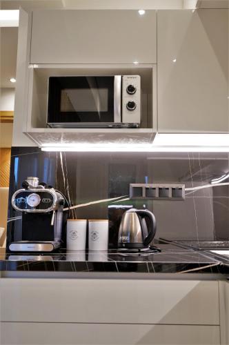 a kitchen with a stove with a toaster and a microwave at Estilo luxury apartment in Kavala