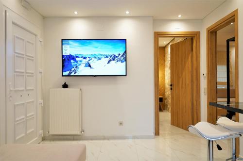 a living room with a tv on the wall at Estilo luxury apartment in Kavala