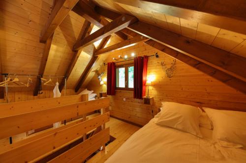 ein Schlafzimmer in einem Blockhaus mit einem Bett darin in der Unterkunft Chalet Anemone in Soultzeren