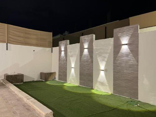 a golf course with artificial grass and lights on a wall at شاليه كارما in Abyār ‘Alī