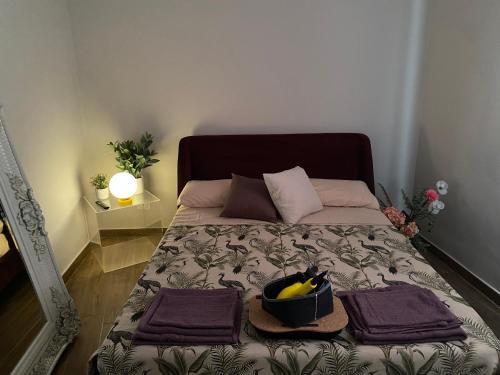 a bed with two purple towels and a bowl of bananas at LaCAsina Appartamento delizioso/nuovo Grosseto centro in Grosseto