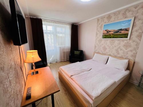 a small bedroom with a bed and a table at Khongor Guest house & Tours in Ulaanbaatar