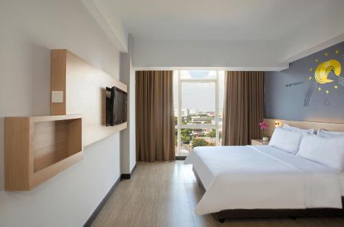una camera d'albergo con letto e TV di Rooms Inc BTC Bandung a Bandung