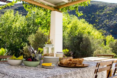 a table with plates and bowls of food on it at Porcupine Hills Olive and Guest Farm in Botrivier
