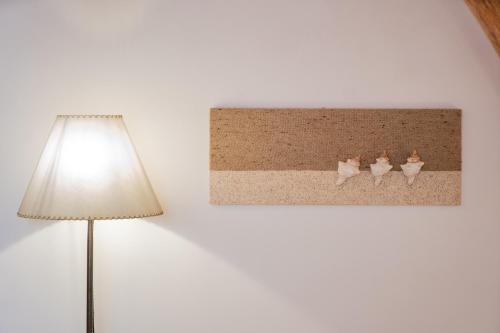 a picture of three cats on a wall next to a lamp at Relais Corte Palmieri & Il Chiostro - Residenza d'epoca in Gallipoli