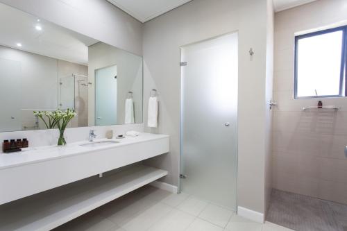 a white bathroom with a sink and a shower at Pearl Valley Hotel by Mantis in Franschhoek