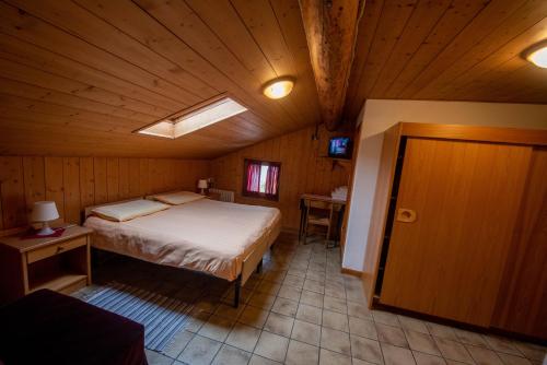 sypialnia z łóżkiem w drewnianym pokoju w obiekcie Hotel Eira w mieście Bormio