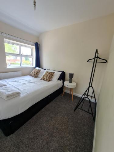 a bedroom with a bed and a cross on the wall at The Grove House with Free Parking in Hull