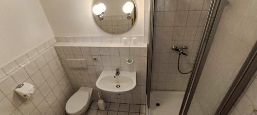 ein Bad mit einem WC, einem Waschbecken und einer Dusche in der Unterkunft Gasthof "Zum Schloss" in Berßel