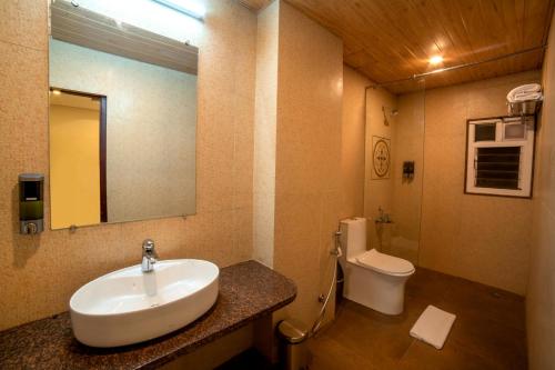 La salle de bains est pourvue d'un lavabo et de toilettes. dans l'établissement The Bliss Hotel, à Hubli