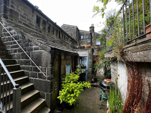 an alley with a staircase next to a brick building at The Well House Boutique Cottage Hebden Bridge Central in Hebden Bridge