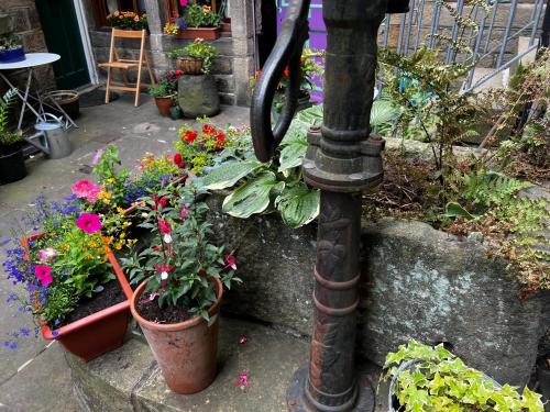 a bunch of flowers in pots on a pole at The Well House Boutique Cottage Hebden Bridge Central in Hebden Bridge