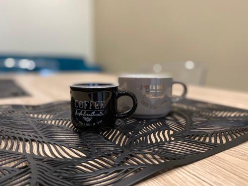 two coffee cups sitting on a tray on a table at Levante apartment and room in Bari