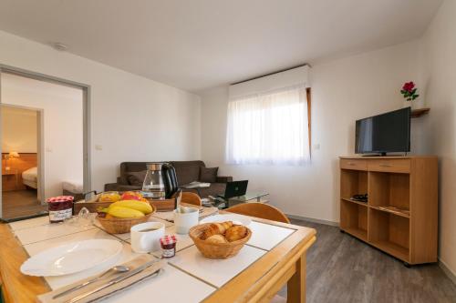 a living room with a table with fruit on it at Cerise Nantes La Beaujoire in Nantes