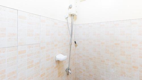uma casa de banho com um chuveiro e uma parede em azulejo em RedDoorz @ Goldland Spring Resort Urdaneta City em Urdaneta