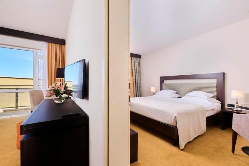 a hotel room with a bed and a window at Hotel Garden Istra Plava Laguna in Umag