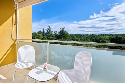 two chairs and a table on a balcony at Hotel Garden Istra Plava Laguna in Umag
